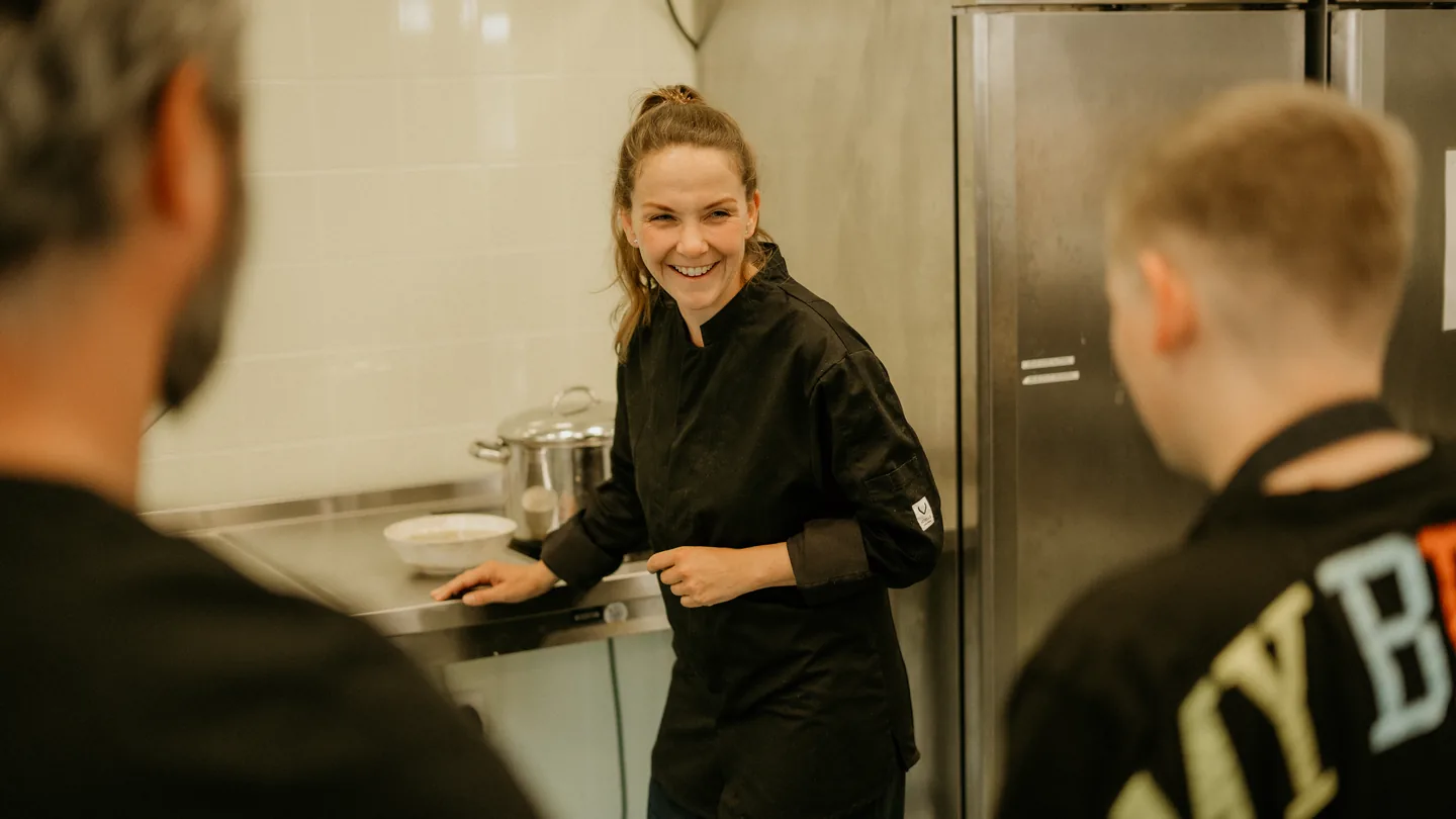 Iris overlegt lachend met het keukenteam