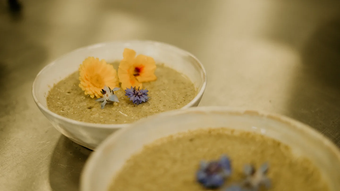 Twee kommen verse soep, afgemaakt met eetbare bloemen