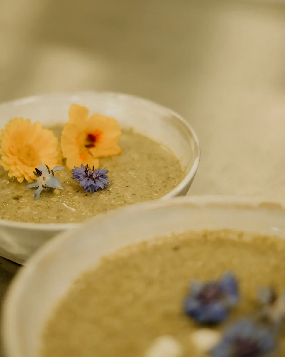 Twee kommen verse soep, afgemaakt met eetbare bloemen