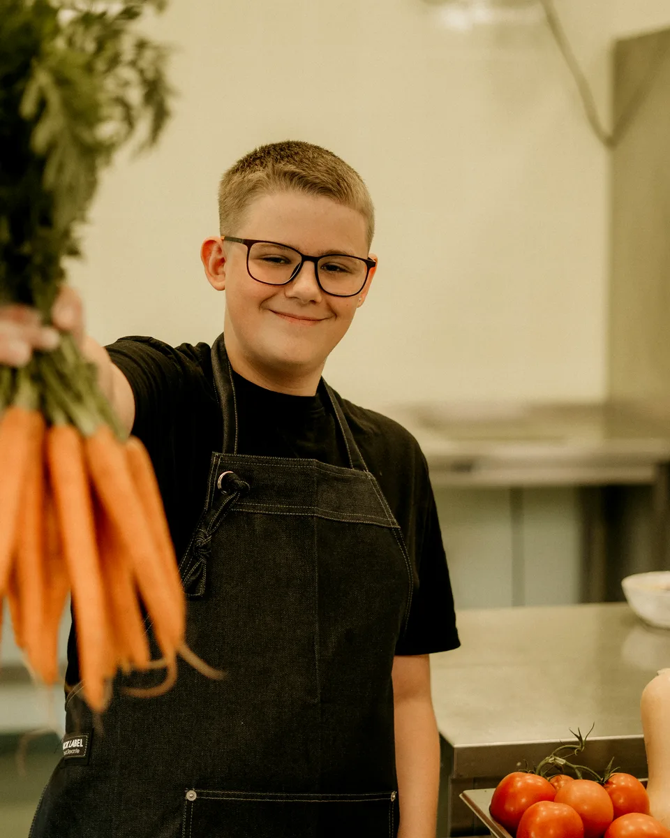 Een jonge maker met verse groenten in de keuken van Soep voor jou