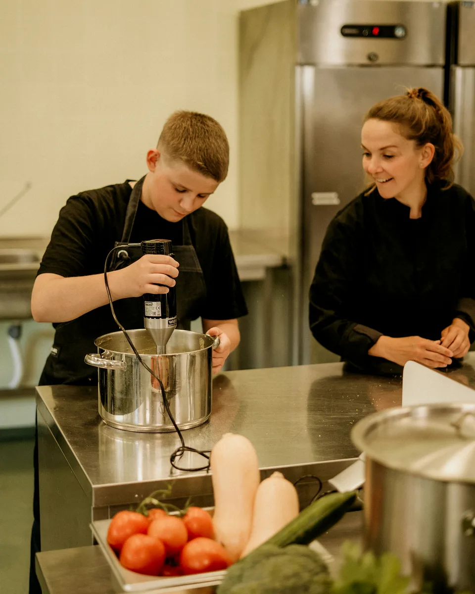 Een jonge maker kookt verse soep in de keuken van Soep voor jou